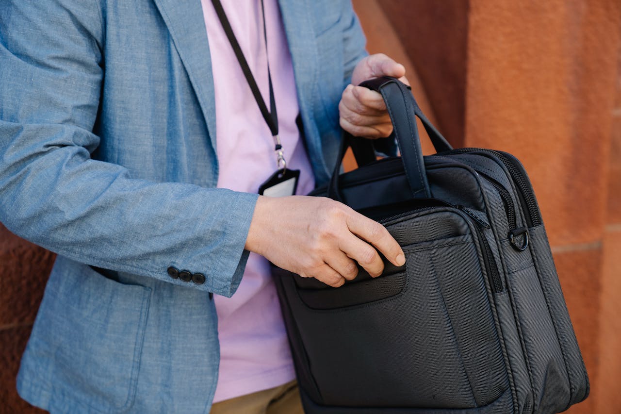 Close-up of a professional in smart casual attire holding a sleek briefcase.